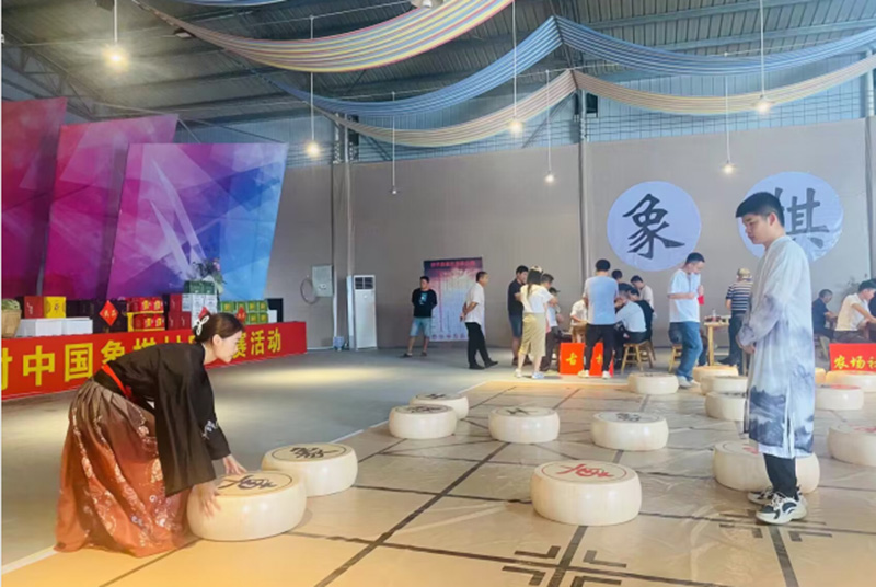 象棋“村甲”00后汉服小姐姐在百米巨型棋盘上移动大棋子同步直播。受访单位供图