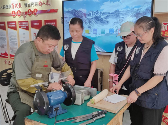 游丹为居民磨刀。张旭 摄