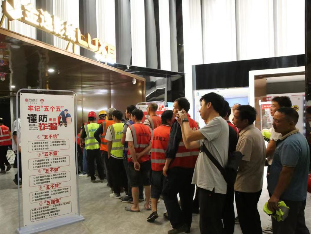参加活动的建筑工人仔细阅读宣传资料。单位供图