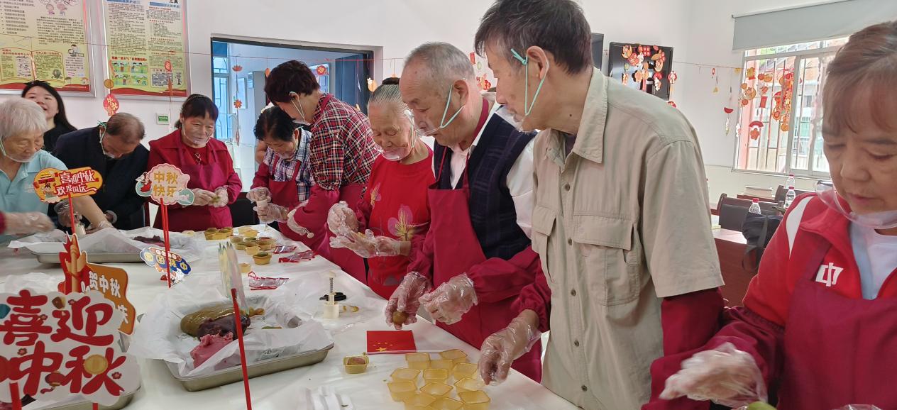 社区居民围在一起制作手工月饼。单位供图