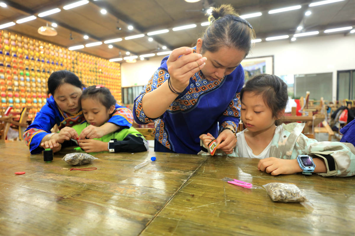 10月5日，来自深圳南山外国语学校（集团）科苑小学的学生在张家界市武陵源区乖幺妹土家族织锦基地学习体验土家族织锦制作技艺。吴勇兵摄