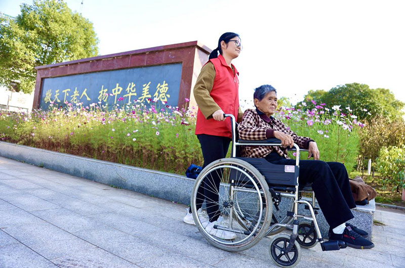 志愿者带着老人散散心。李根摄