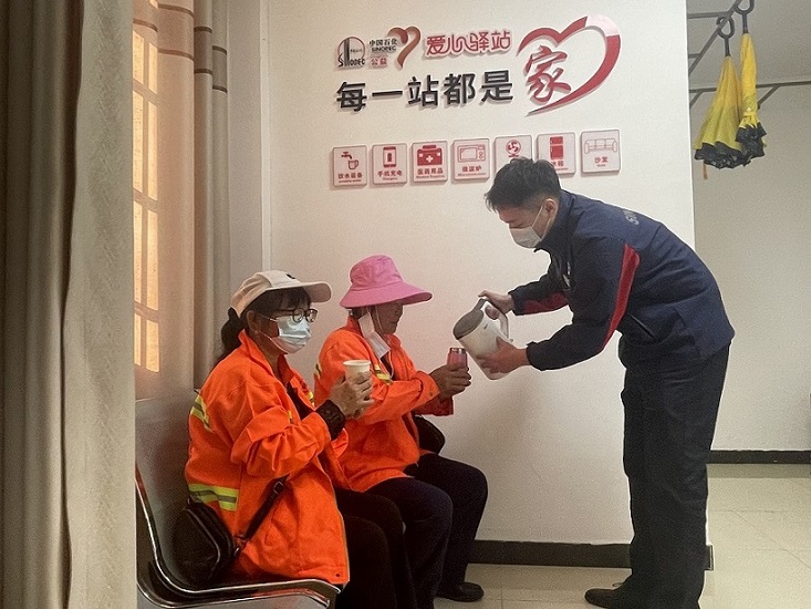 中石化湖南岳阳石油通海南路加能站站长为环卫工人添热水。受访单位供图