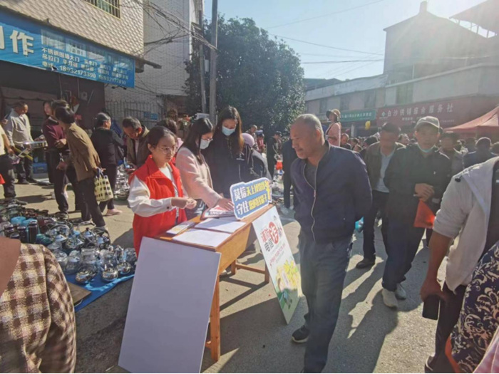 工作人员在集市上开展反诈宣传。单位供图