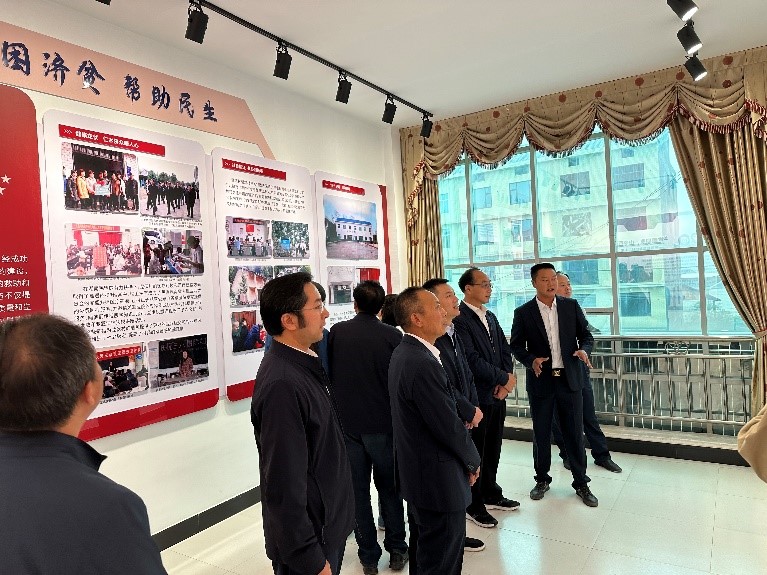 龙伏村支委委员刘志广借助展板向大家介绍美丽乡村龙伏村的蝶变之路。单位供图
