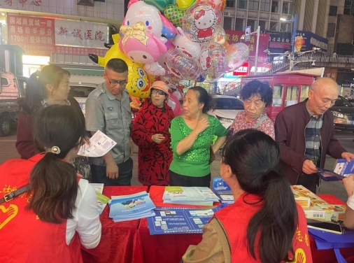摊位前群众咨询社保政策（单位供图）