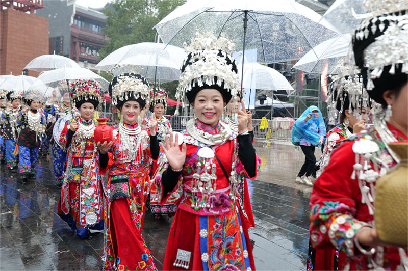 雨中，身穿盛裝的苗家姑娘熱情的打招呼。 吳東林攝