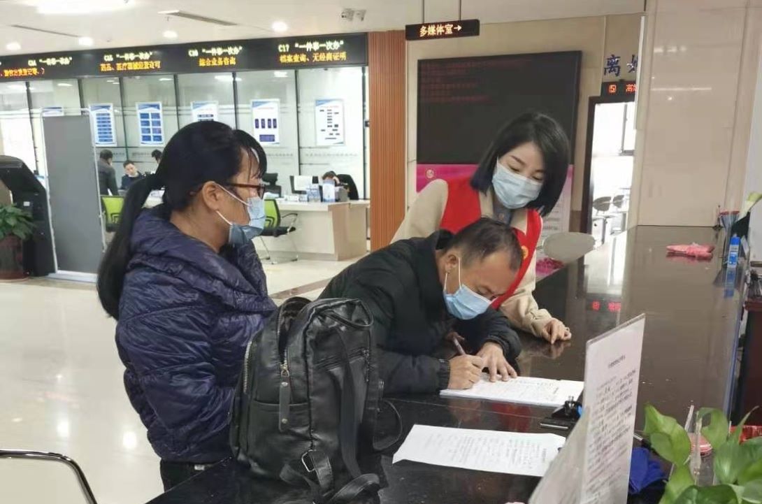 攸县政务服务中心志愿者协助群众办理业务。单位供图