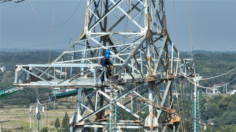 国网湖南送变电公司员工在益阳东500千伏变电站配套线路工程D18号施工现场进行紧挂线工作，全力推进工程建设。受访单位供图