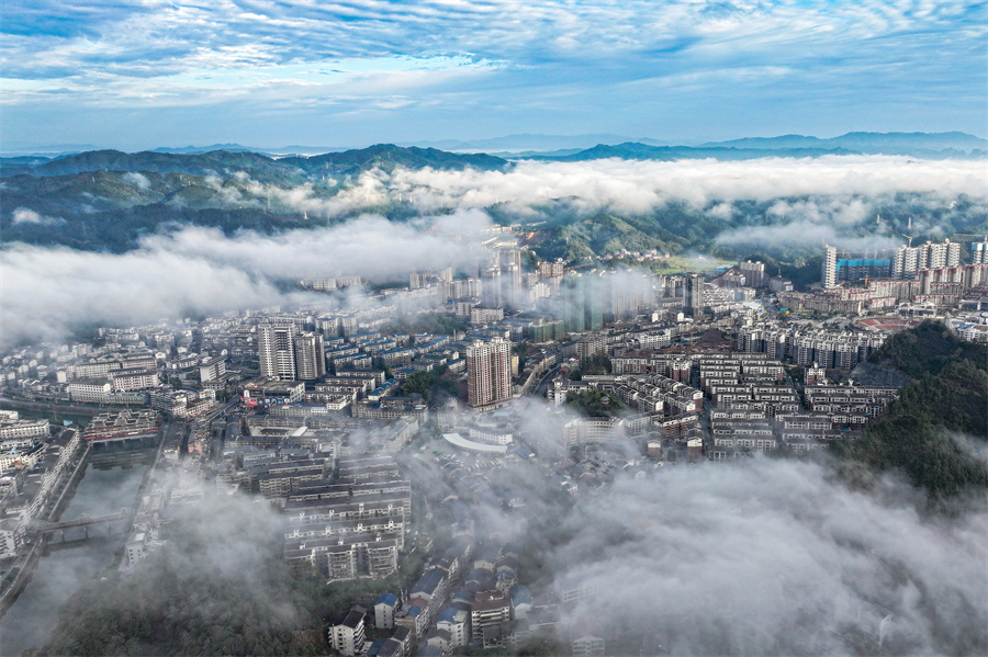 群山、城市建筑在大雾中若隐若现。石猛雷摄