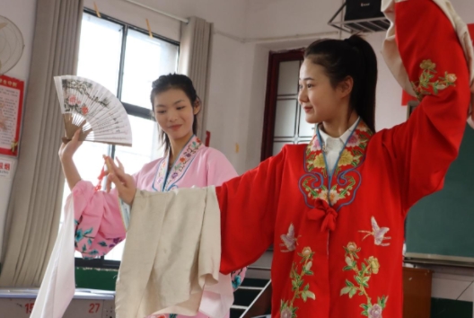11月23日在邵阳市双清区五里牌小学，湖南省祁剧保护传承中心的老师表演折扇。单位供图