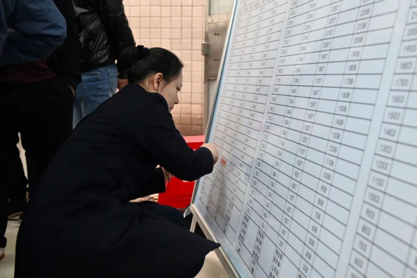 安置户代表们查看房源摇号公示榜。单位供图