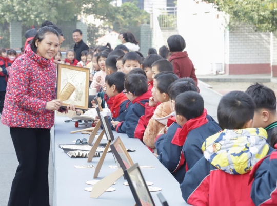 非遗传承人向学生展示非遗技艺宝庆烙画。（单位供图）