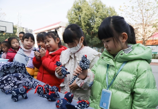 学生在非遗文化展览区认真观看蓝印花布工艺品。（单位供图）