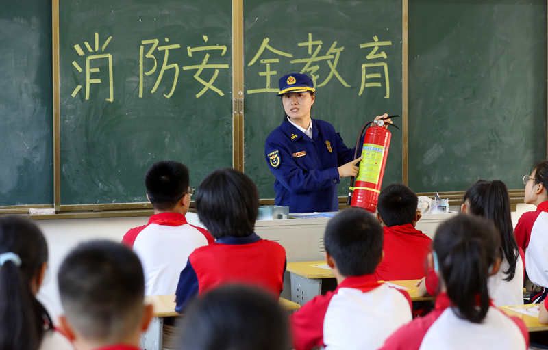 周宇坤向学生讲解灭火器的使用方法。郴州消防供图