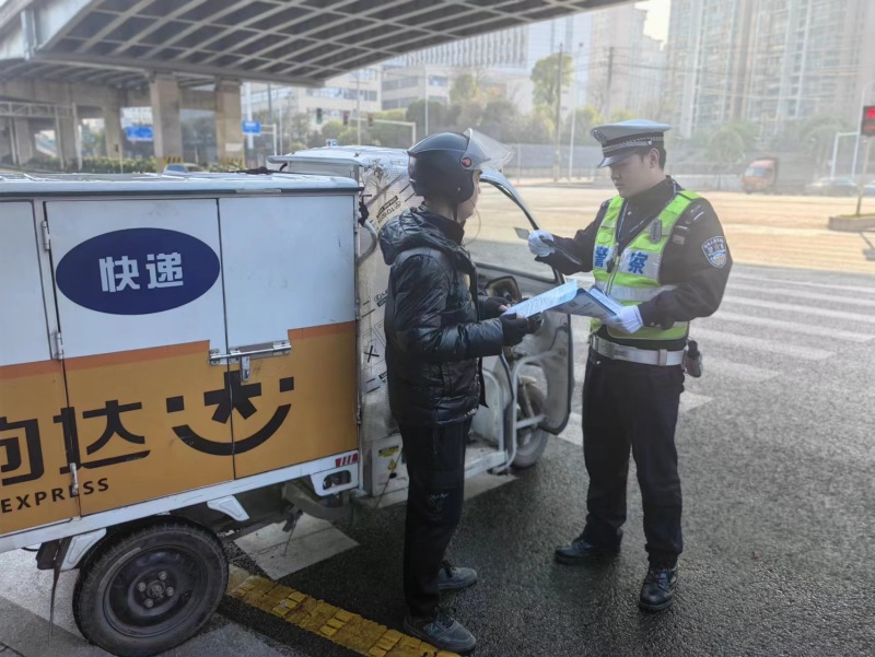 交警在查看快遞小哥的車輛駕駛証。受訪單位供圖