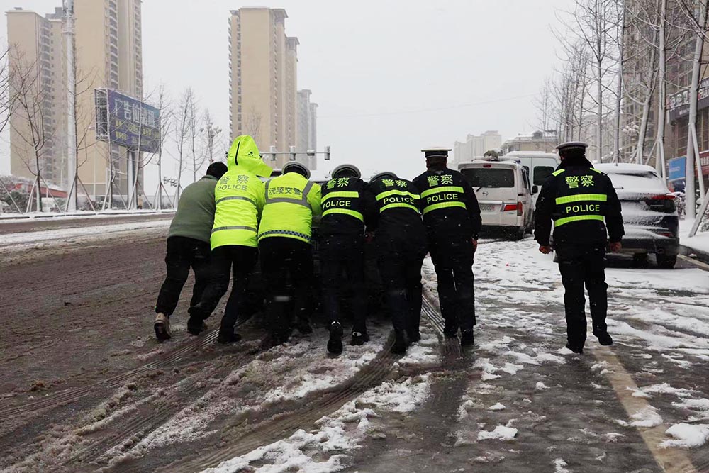 公安交警协力推车。资料图