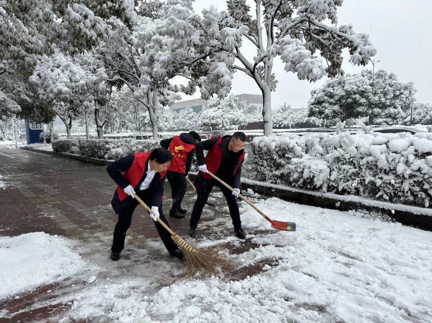 长沙县民政局组织40名职工齐心协力，铲除积雪，确保市民正常、安全出行。单位供图
