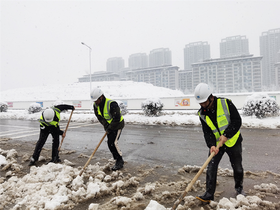志愿者在进行道路除冰扫雪。受访单位供图