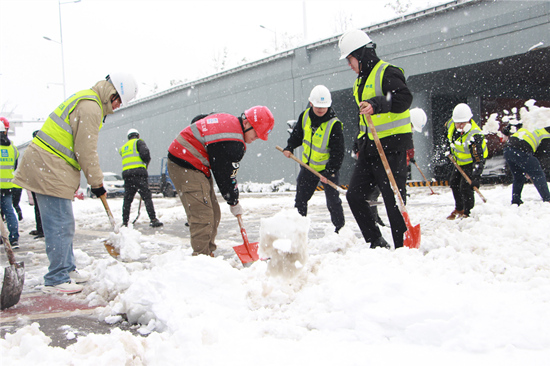 志愿者在进行道路除冰扫雪。受访单位供图