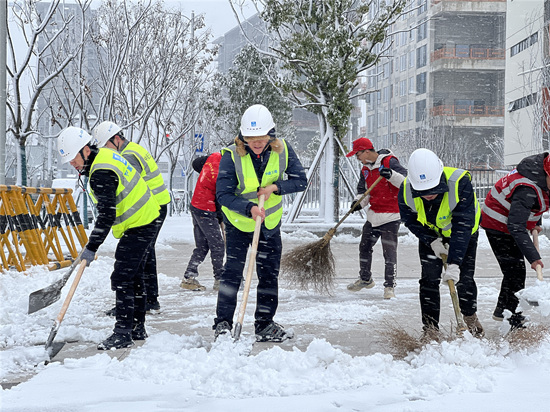 志愿者在进行道路除冰扫雪。受访单位供图