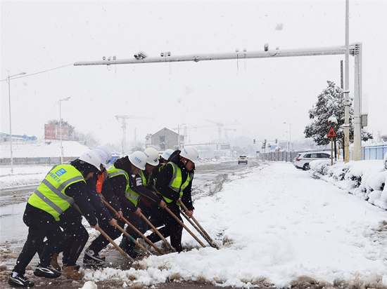志愿者在进行道路除冰扫雪。受访单位供图
