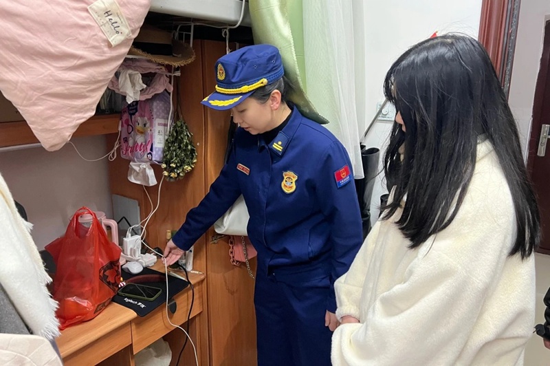 对学生宿舍进行消防安全排查，提醒学生安全用电（单位供图）