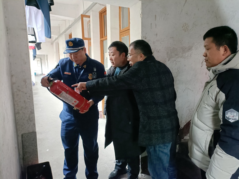 消防监督员对学校内的消防器材进行检查（单位供图）