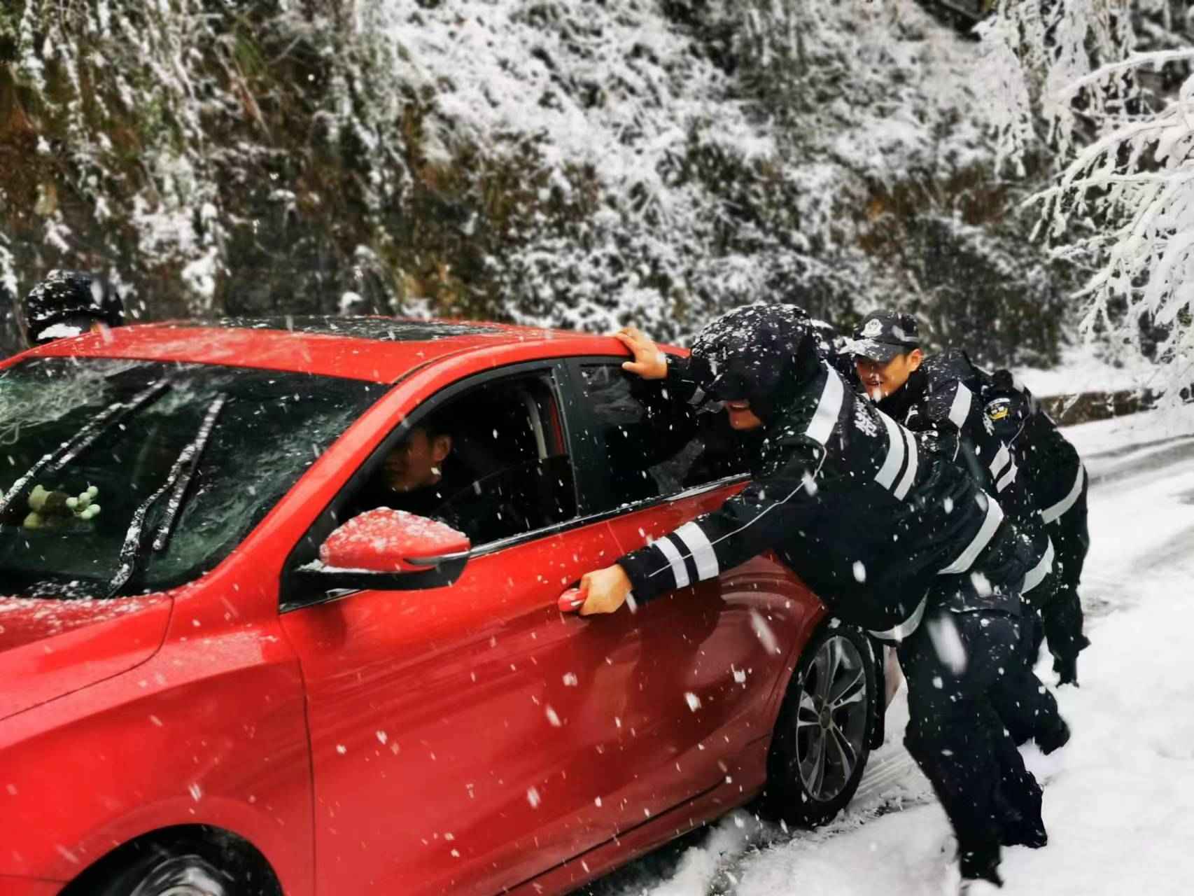 2024年1月22日，吉首市公安局机动队迅速组织警力对红枫林场路段开展扫雪除冰工作，并帮助受困车辆转移。单位供图