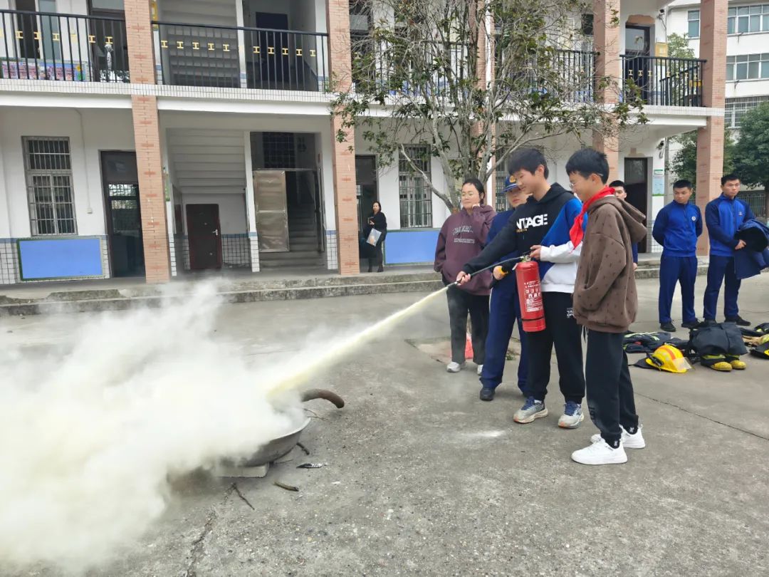 消防宣传员正在教学生使用灭火器（单位供图）