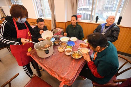 天心区赤岭路社区暖心厨房，工作人员（左一）为老人盛汤。单位供图