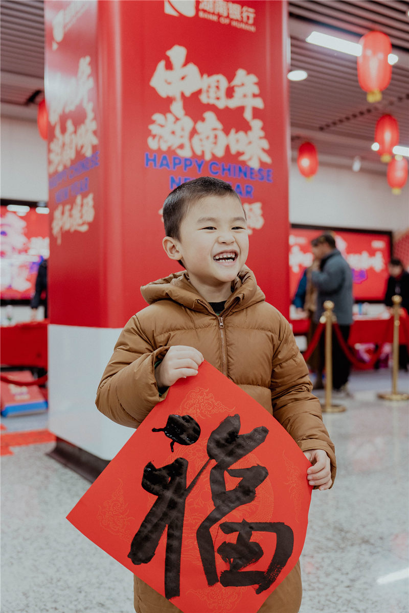 孩子拿着书法家写的福字。受访单位供图