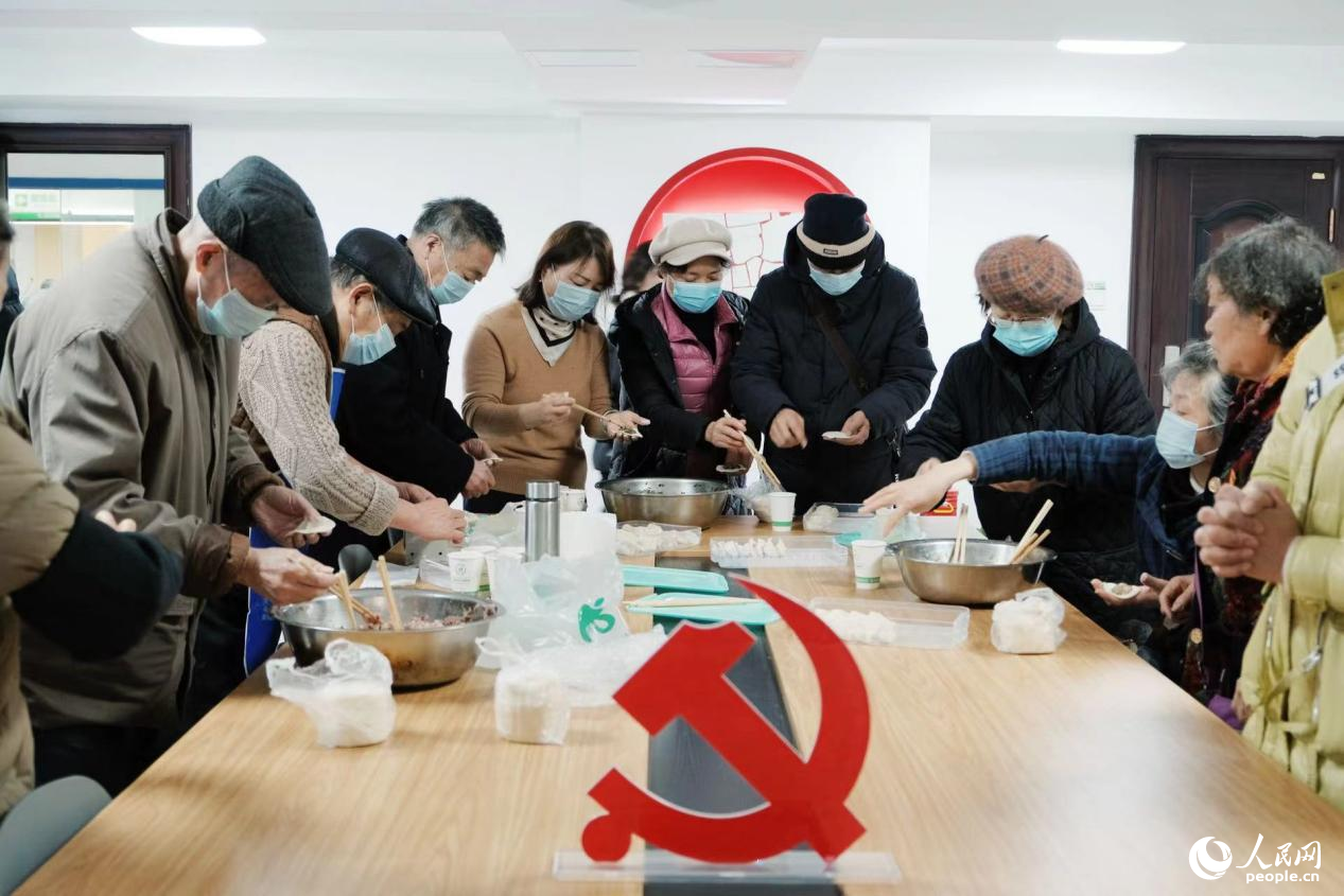熙台岭社区居民围在一起包饺子。 人民网记者 向宇摄