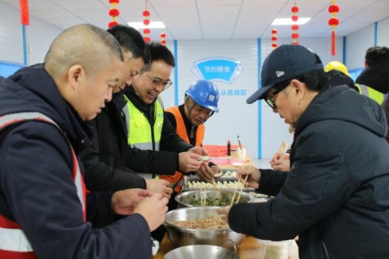 工友和管理人员包饺子。受访单位供图