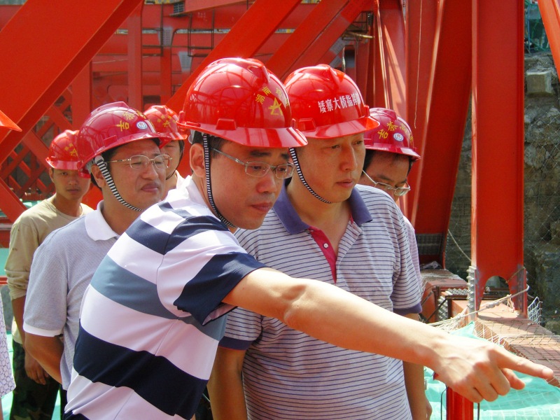 胡建华(前一)在桥梁建设现场。受访单位供图