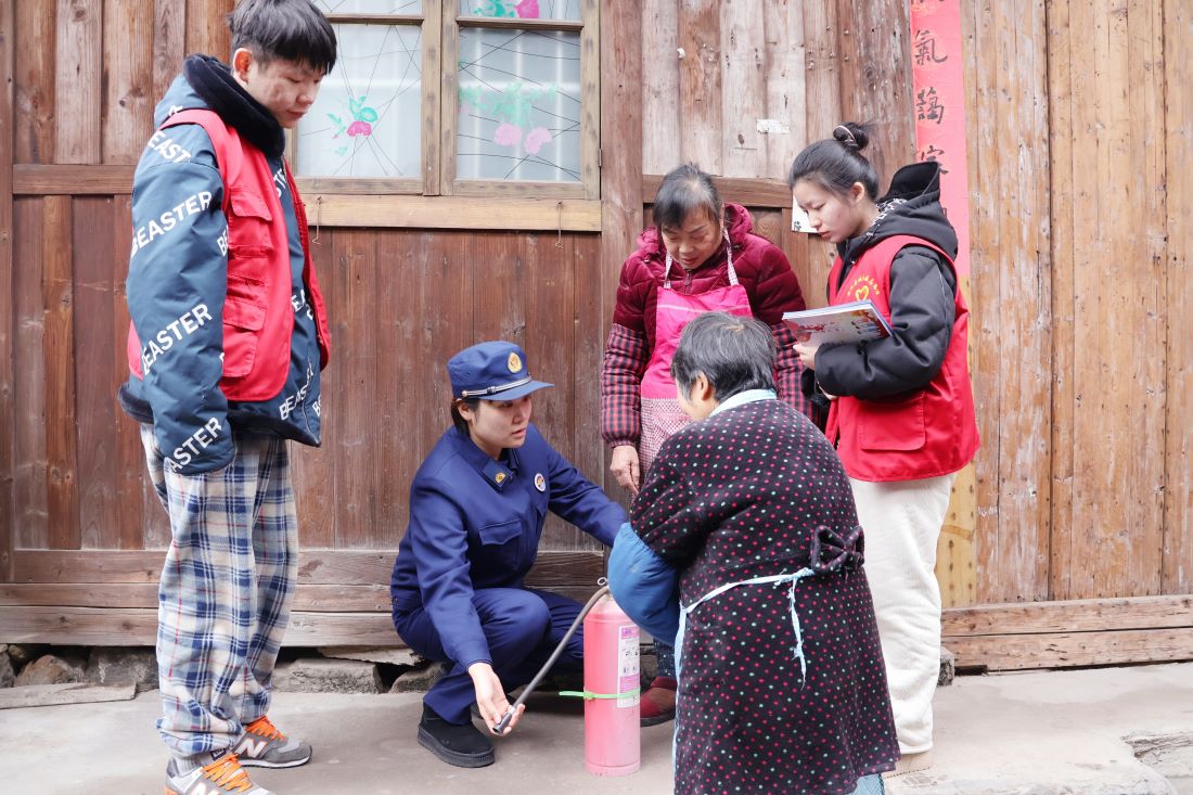 消防宣传员邓文婕为村民讲解灭火器使用方法（单位供图）
