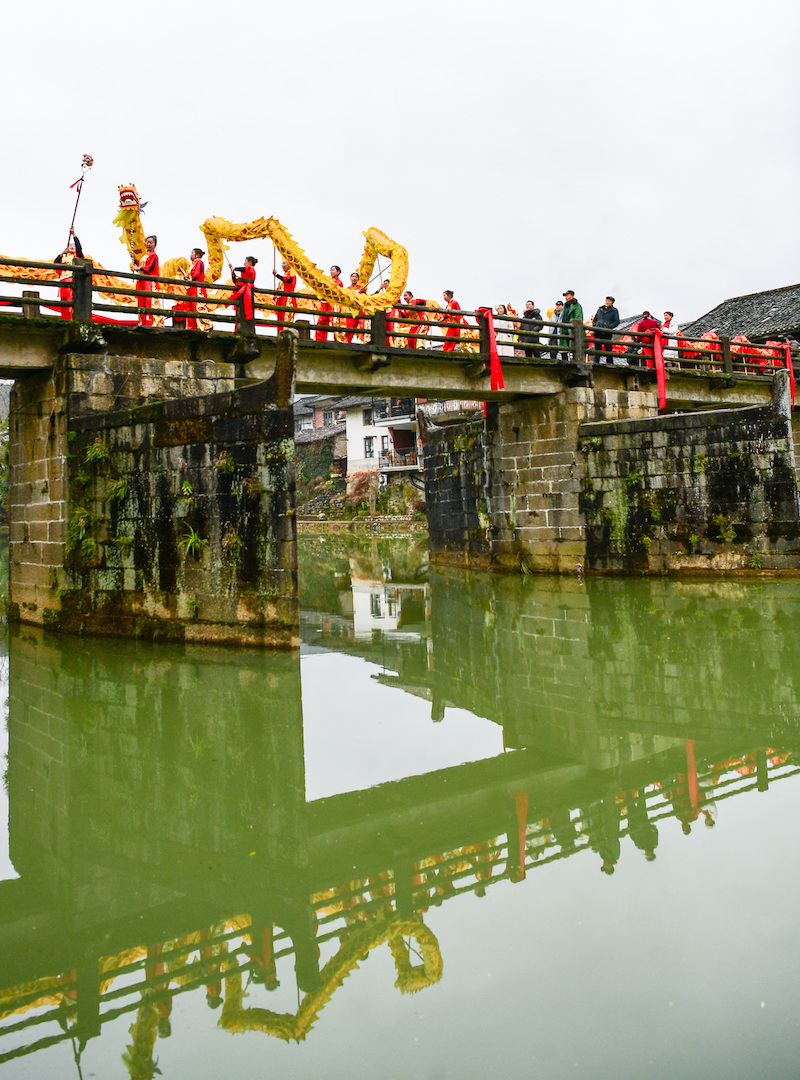 舞龙队巡游来到万福古桥，舞出佳节好兆头。彭红霞摄