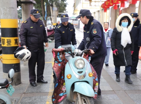 执法队员将违规停放的非机动车辆搬移至停车位内（单位供图）