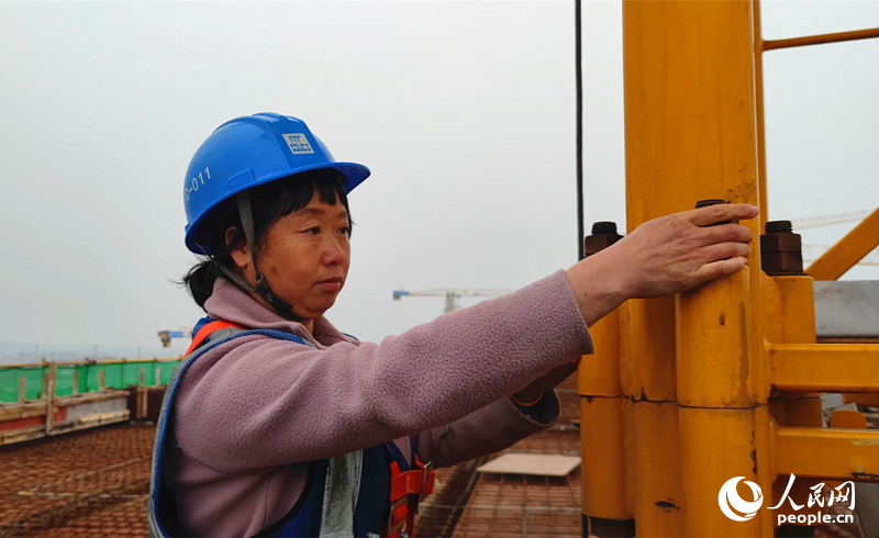 陳雪蓮在檢查塔吊標准節的螺栓。人民網記者 劉賓攝