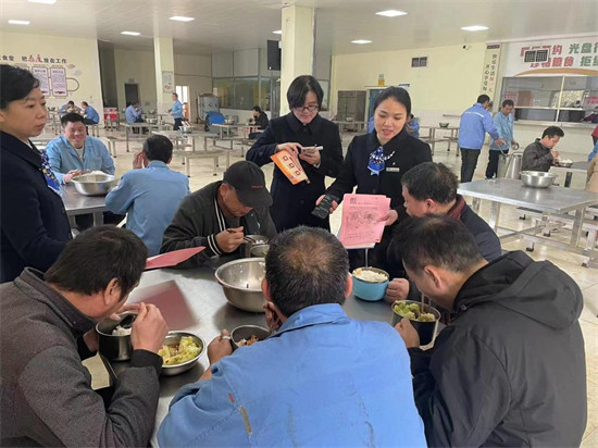 建行工作人员在食堂为工友普及金融知识。企业供图