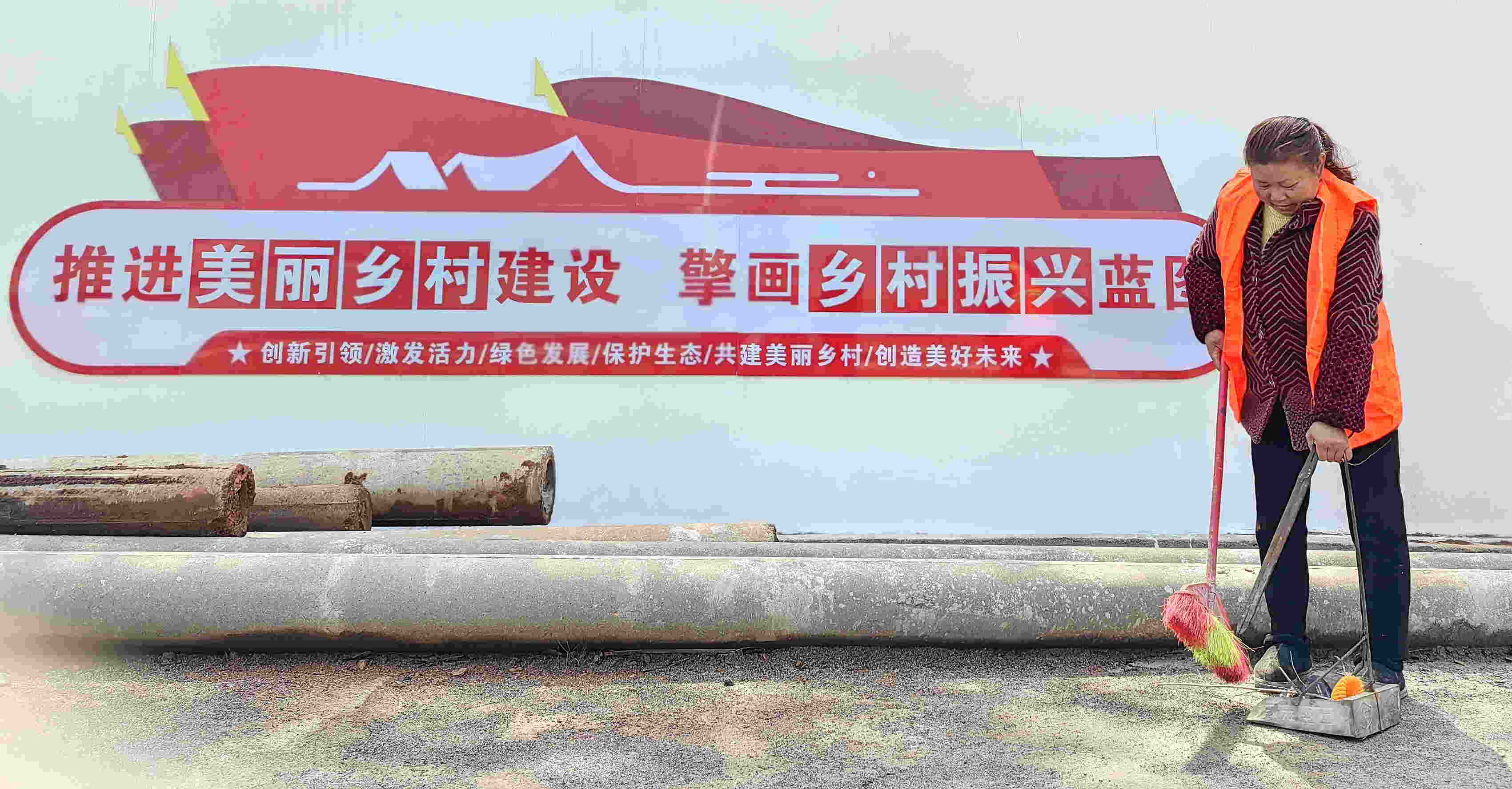 廖平香正在清理路旁垃圾(单位供图)