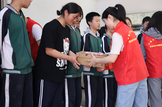 志愿者给孩子们发放礼物。受访单位供图
