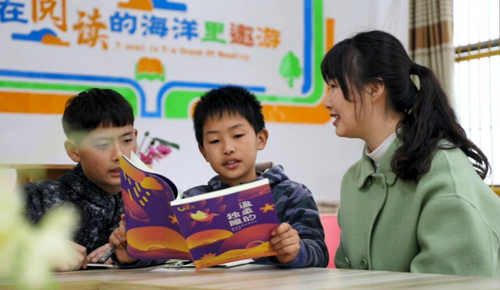 枧头学校教师王云指导学生阅读课外书籍。黄新摄