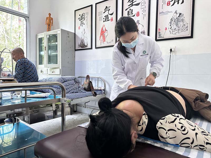 全春梅在治疗室给病人做针灸。胡雅萍摄