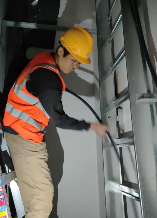 工人往電井橋架放電纜。受訪單位供圖