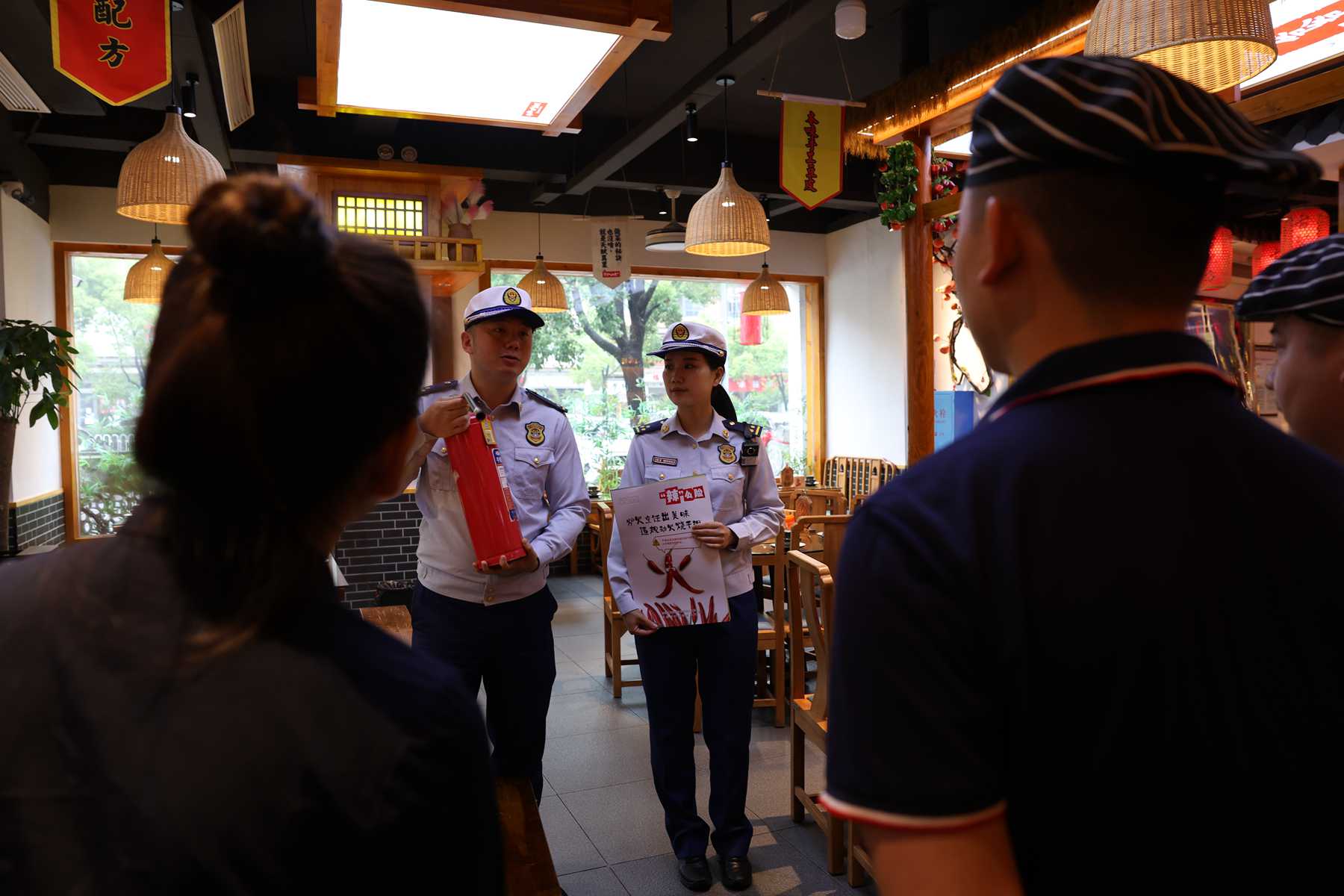 消防监督员开展餐饮场所消防宣传（单位供图） 