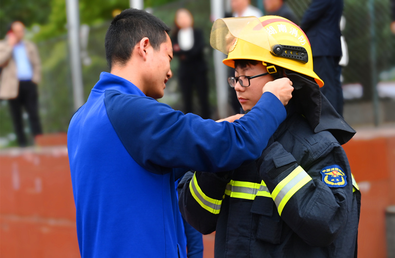 学生试穿消防服。邵阳城步消防供图