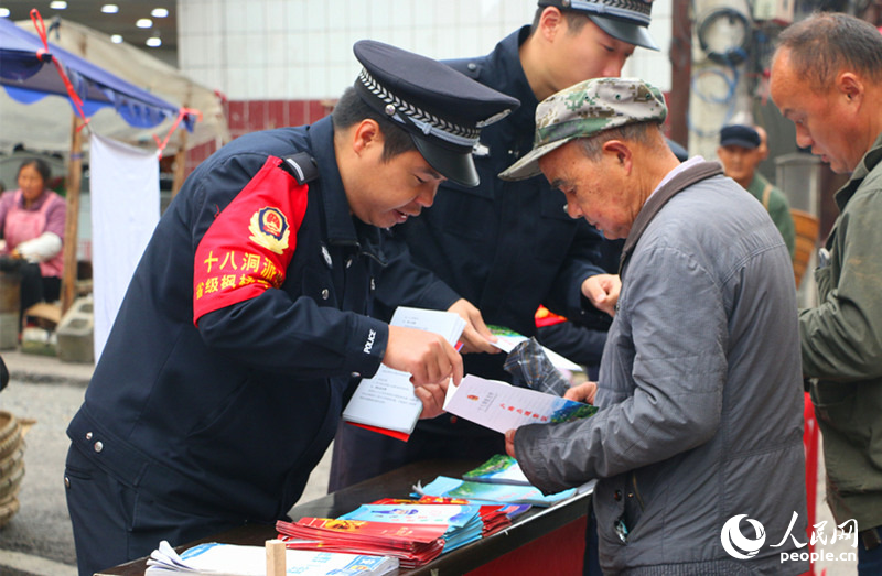 十八洞派出“集市警務”現場向群眾宣傳法律法規知識。人民網記者 劉賓攝