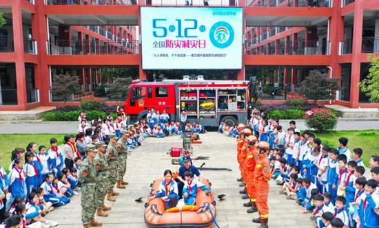 学生在消防员和民兵的指导下，体验救援皮划艇的使用。刘贵雄摄