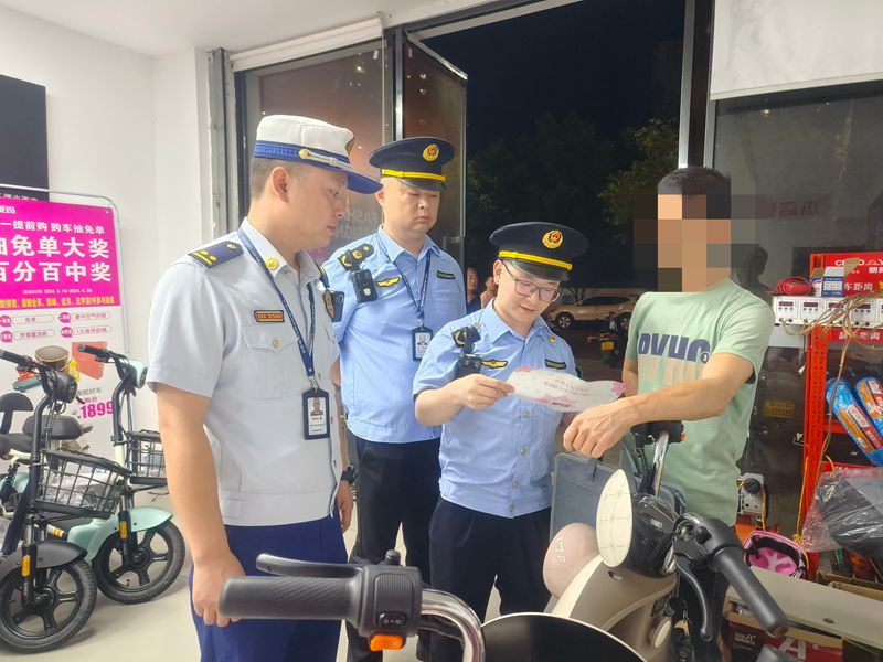 检查人员对电动自行车的经营店铺进行检查并进行安全宣传。（单位供图）